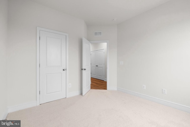 unfurnished bedroom featuring carpet, visible vents, and baseboards