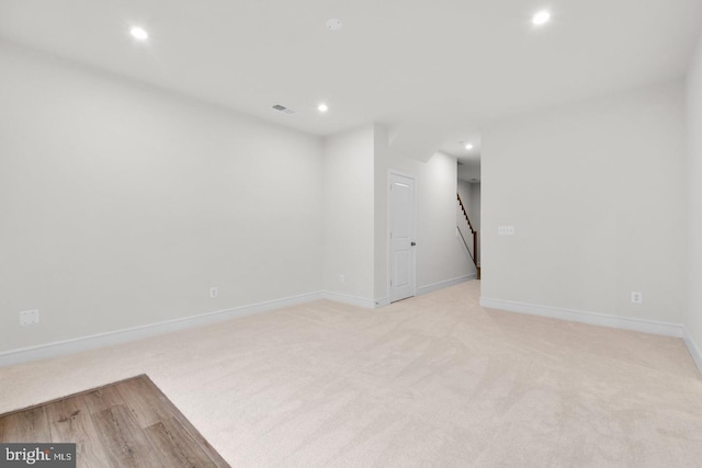 spare room featuring baseboards, light colored carpet, visible vents, and recessed lighting