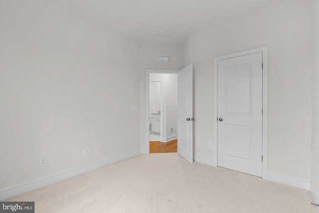 unfurnished bedroom with carpet, visible vents, and baseboards