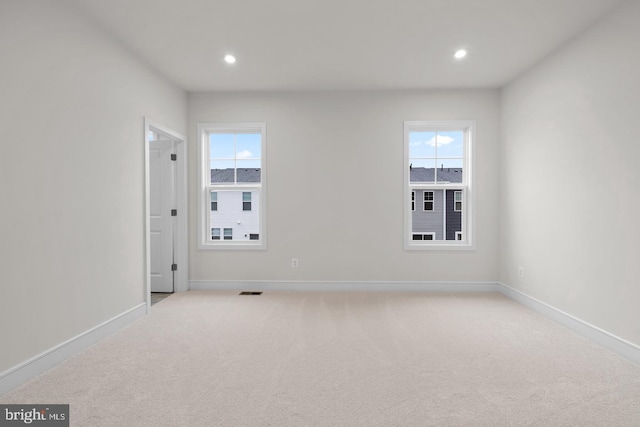 empty room with recessed lighting, light colored carpet, and baseboards