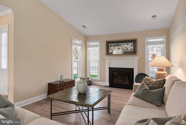 living room with lofted ceiling, light wood-style floors, baseboards, and visible vents