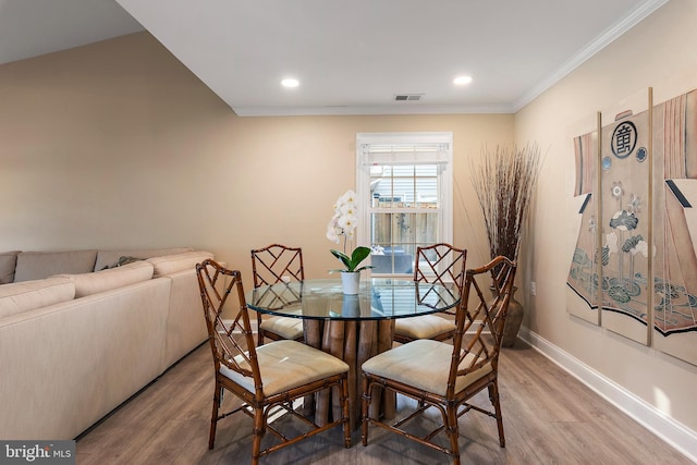 dining area with visible vents, ornamental molding, and wood finished floors