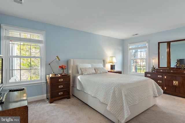 bedroom featuring light colored carpet, visible vents, and baseboards