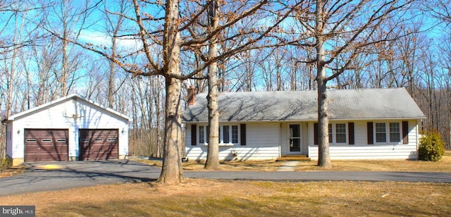 ranch-style house with a garage, an outbuilding, and a front lawn