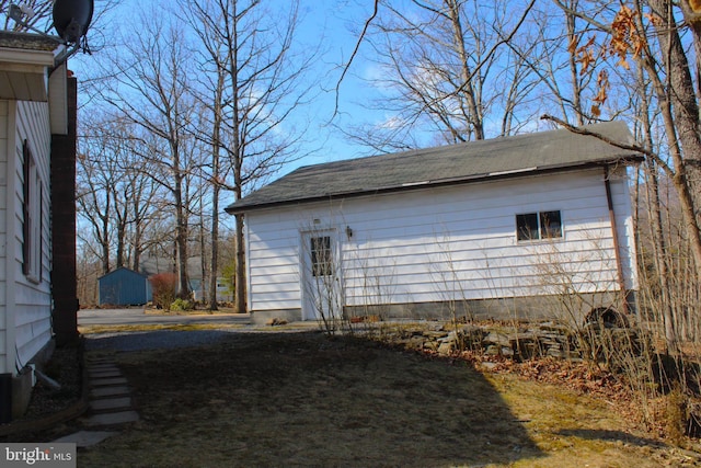 view of home's exterior with an outbuilding