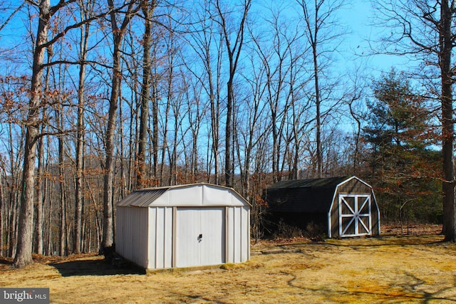 view of shed with a wooded view