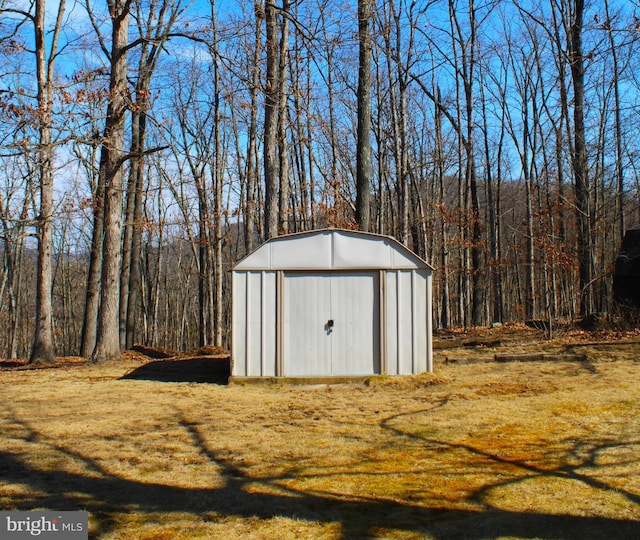 view of shed with a wooded view