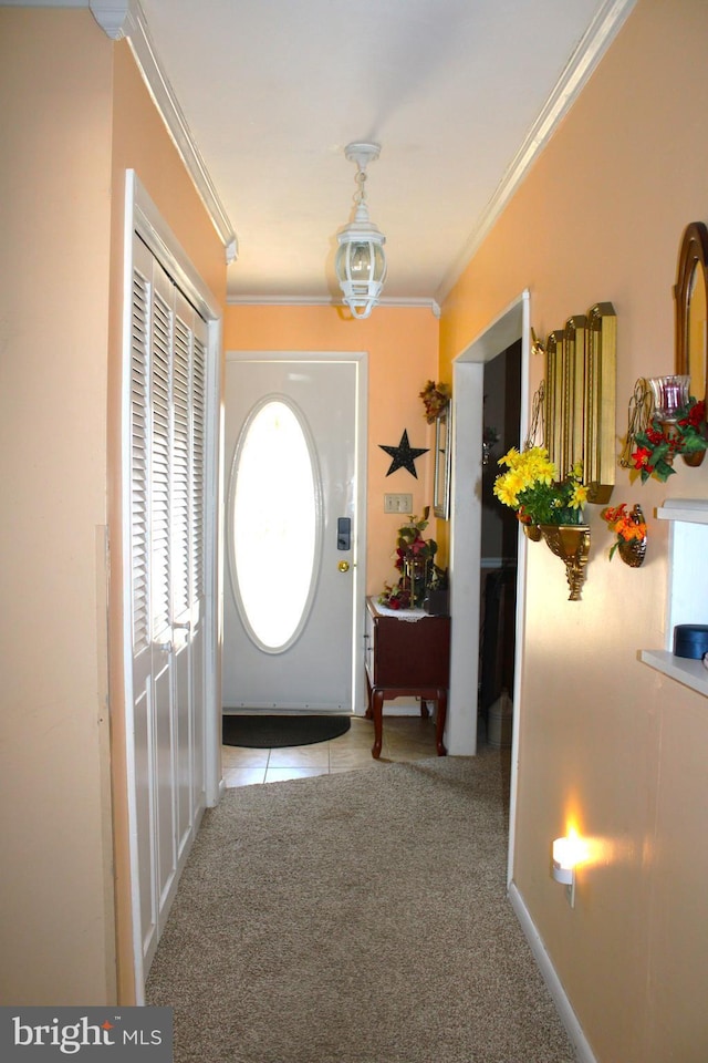 doorway featuring tile patterned flooring, carpet, and crown molding