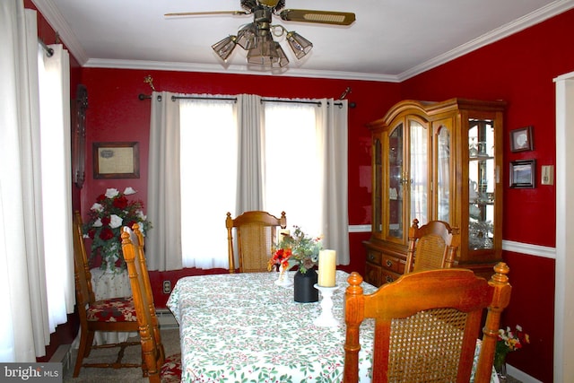 dining space with a ceiling fan and crown molding