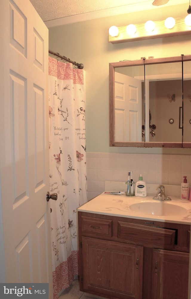 full bathroom featuring tile walls, vanity, and a textured ceiling