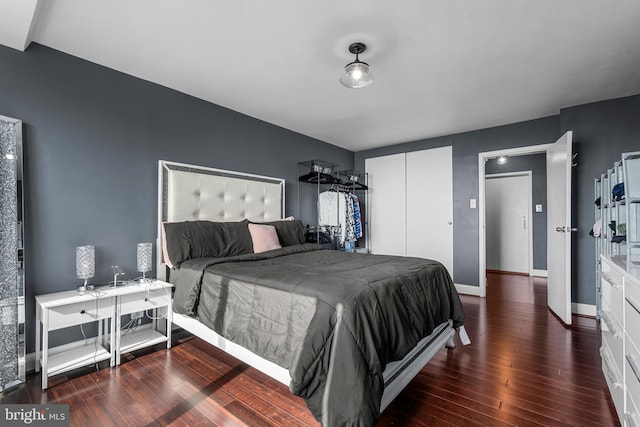 bedroom featuring a closet, baseboards, and wood finished floors