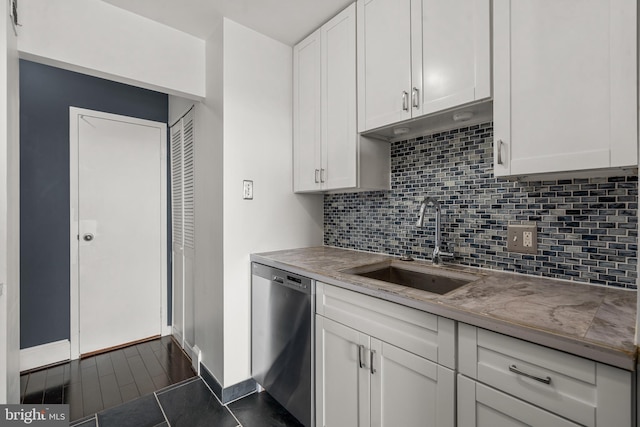 kitchen featuring tasteful backsplash, white cabinetry, dishwasher, and a sink