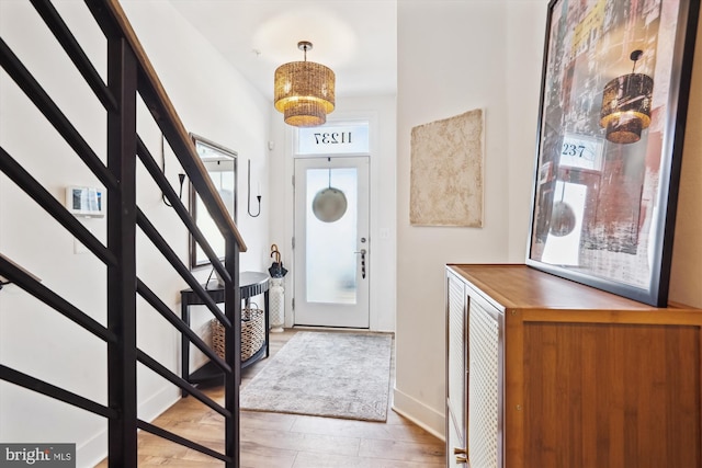 entrance foyer featuring stairs, wood finished floors, and baseboards