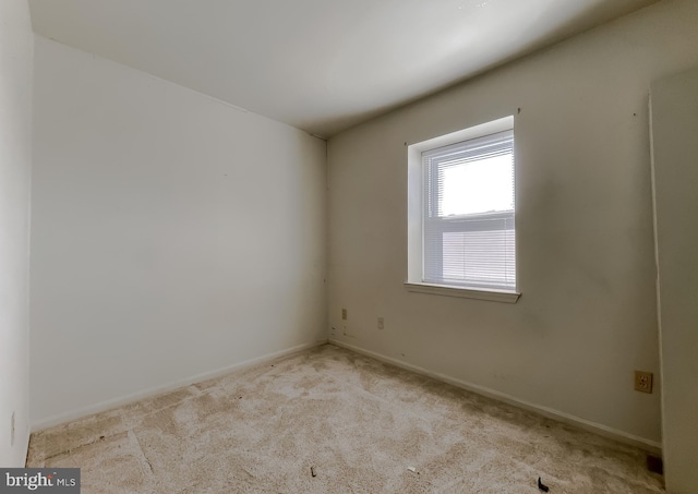 spare room featuring carpet and baseboards