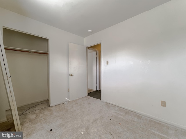 unfurnished bedroom featuring carpet floors, a closet, and baseboards