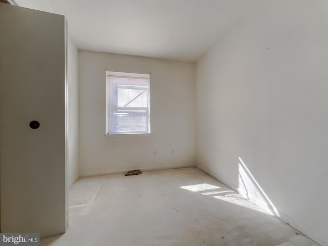 unfurnished room with concrete flooring