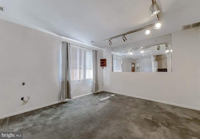 unfurnished room featuring carpet floors, baseboards, visible vents, and track lighting