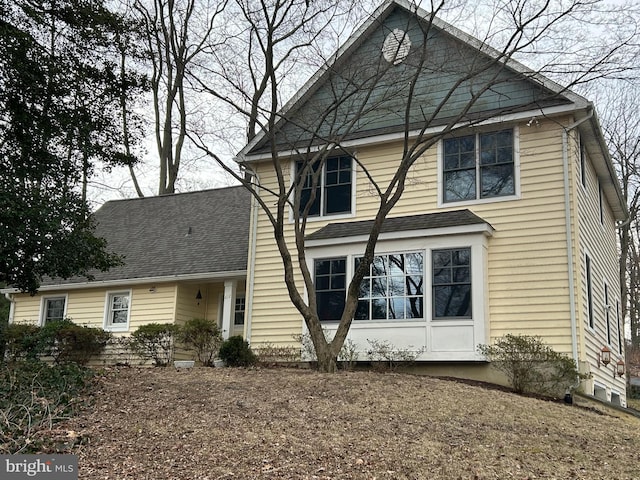 traditional-style home featuring roof with shingles