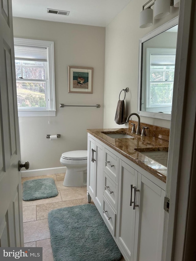 bathroom featuring visible vents, baseboards, toilet, and vanity