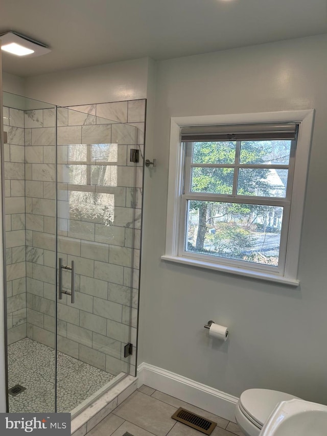 full bath featuring baseboards, visible vents, a stall shower, tile patterned floors, and toilet