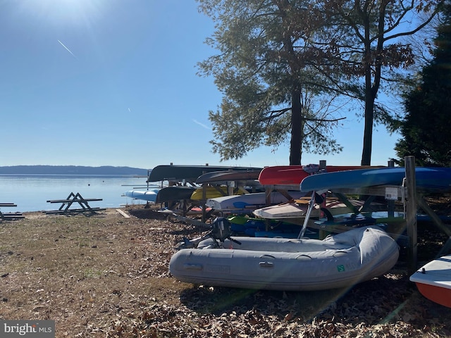 view of vehicle parking with a water view and a dock