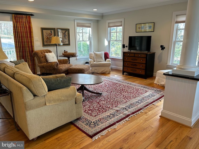 living area featuring baseboards, ornate columns, light wood-style flooring, recessed lighting, and crown molding