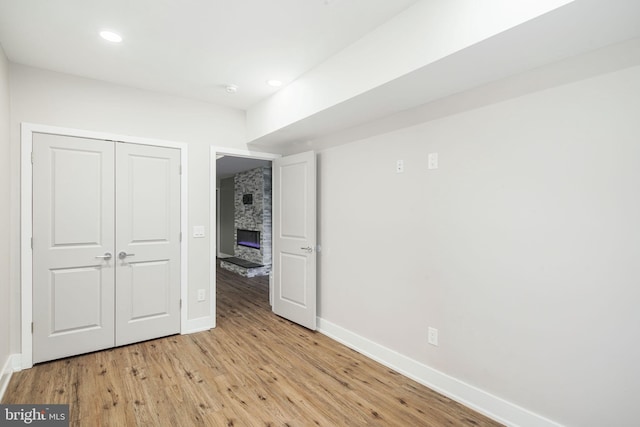 unfurnished bedroom with light wood finished floors, a closet, recessed lighting, and baseboards