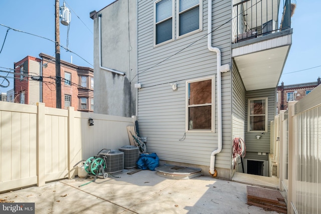 back of house with a patio area, a fenced backyard, and central air condition unit