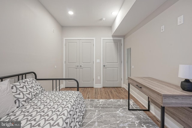 bedroom with a closet, baseboards, and wood finished floors