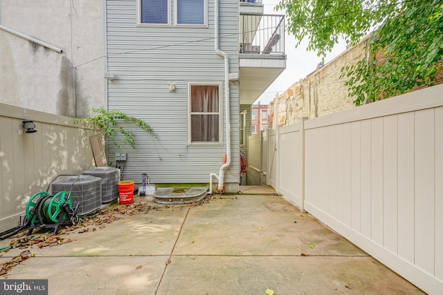 rear view of house with a patio area, a fenced backyard, and central AC unit