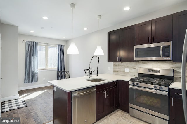 kitchen with stainless steel appliances, tasteful backsplash, a sink, and light countertops