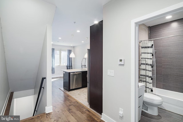 interior space with an upstairs landing, recessed lighting, baseboards, and light wood finished floors