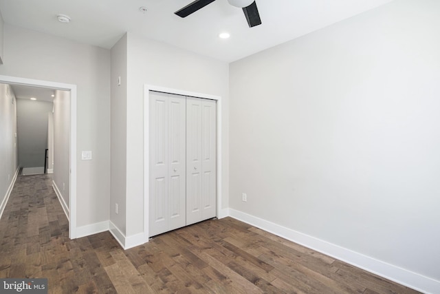 unfurnished bedroom with recessed lighting, a closet, baseboards, and wood finished floors