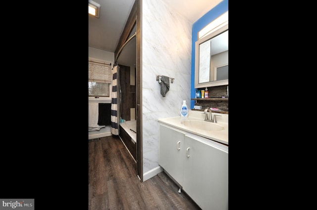 full bath featuring shower / bath combination with curtain, vanity, tile walls, and wood finished floors