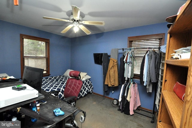 carpeted bedroom with ceiling fan and baseboards