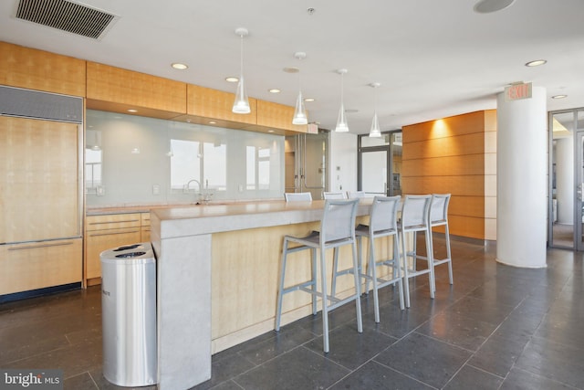 kitchen with visible vents, light countertops, light brown cabinetry, paneled fridge, and recessed lighting