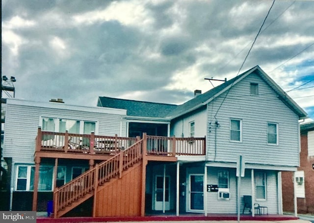 rear view of house featuring stairway and a wooden deck