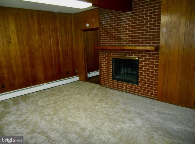 unfurnished living room with carpet floors, baseboard heating, a large fireplace, wood walls, and beamed ceiling