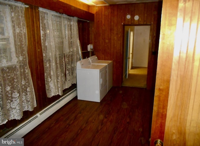 laundry area with laundry area, wooden walls, washer and clothes dryer, dark wood finished floors, and baseboard heating