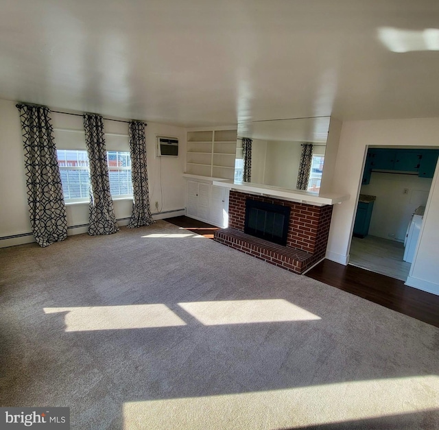 unfurnished living room featuring carpet floors, a fireplace, wood finished floors, baseboards, and a wall mounted AC