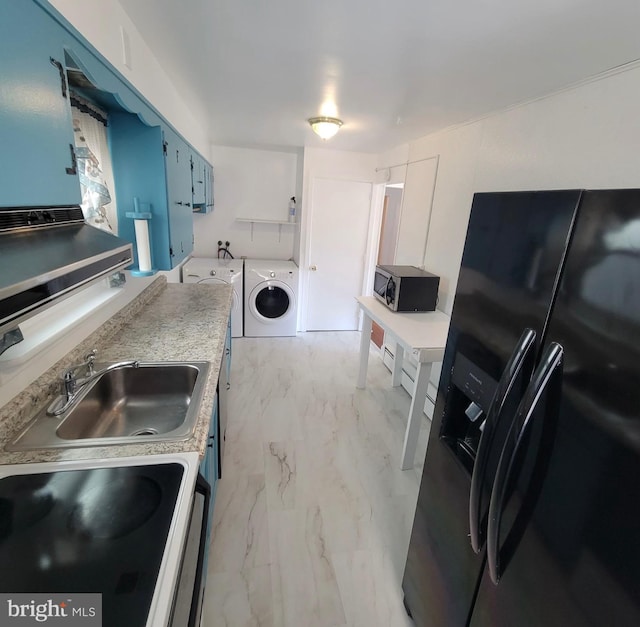 kitchen with blue cabinets, a sink, black refrigerator with ice dispenser, stainless steel microwave, and washing machine and clothes dryer