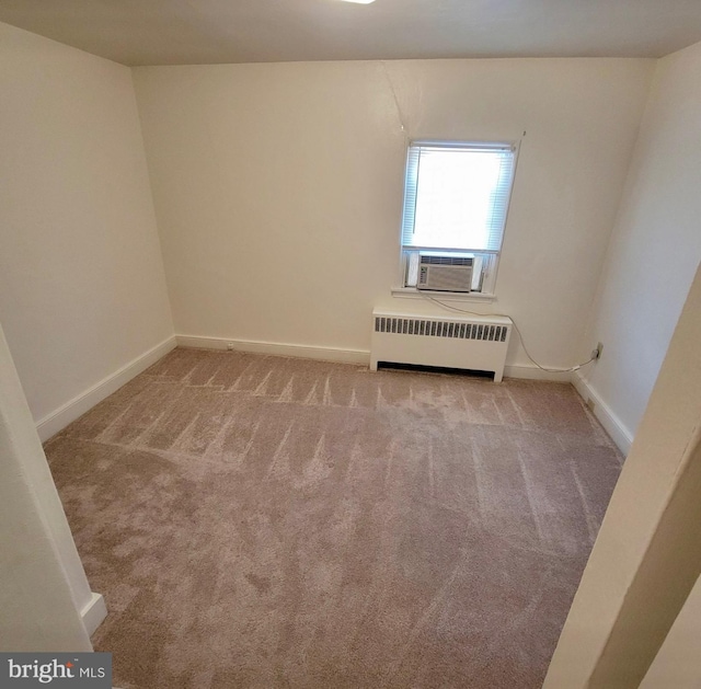 unfurnished room featuring radiator, cooling unit, baseboards, and carpet flooring