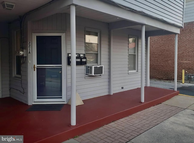 doorway to property featuring covered porch and cooling unit