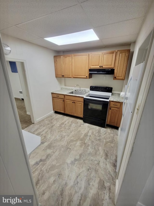 kitchen featuring a paneled ceiling, under cabinet range hood, a sink, and electric range