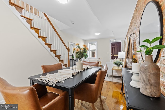 dining space featuring wood-type flooring and stairway