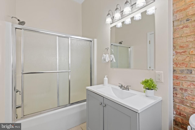 full bathroom featuring shower / bath combination with glass door, vanity, and brick wall