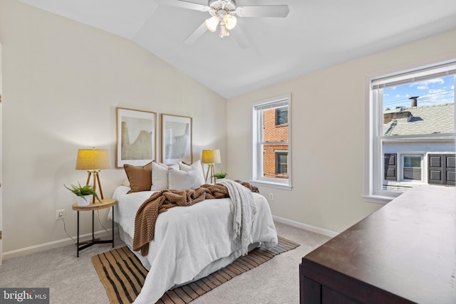 bedroom with light carpet, baseboards, vaulted ceiling, and a ceiling fan