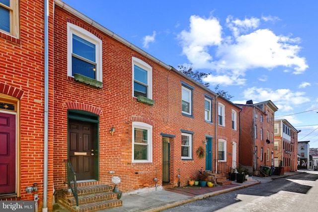 view of front of home featuring entry steps and brick siding