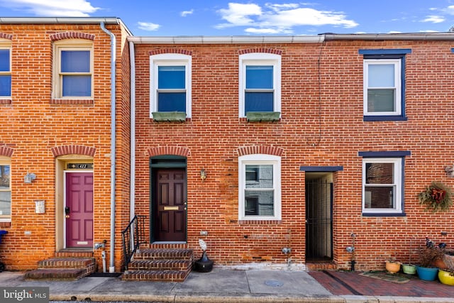 townhome / multi-family property with entry steps and brick siding