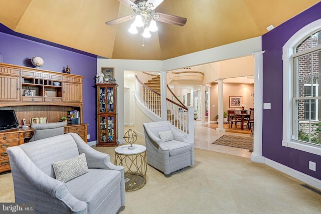 sitting room featuring visible vents, light colored carpet, ceiling fan, ornate columns, and high vaulted ceiling